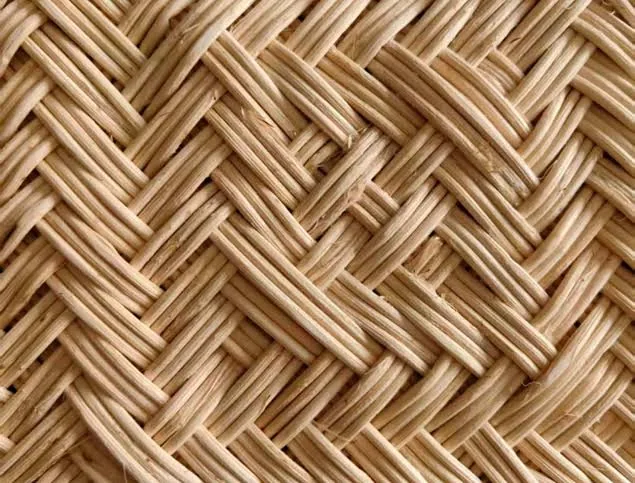 Macro close-up of hand-woven natural rattan strands in a herringbone twill pattern