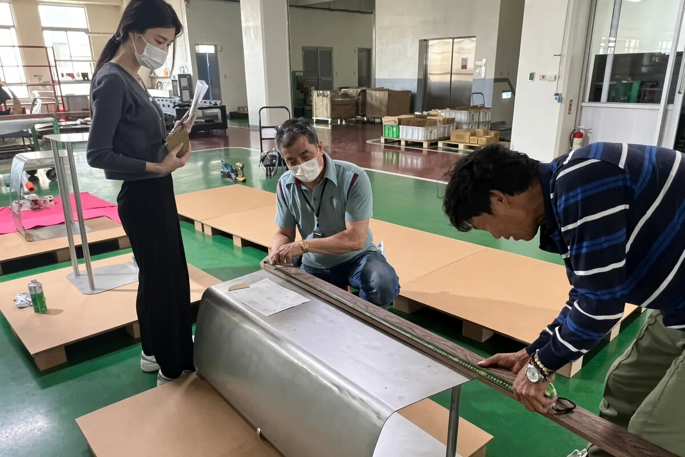 Workers assembling furniture frames and cushions at a factory bench