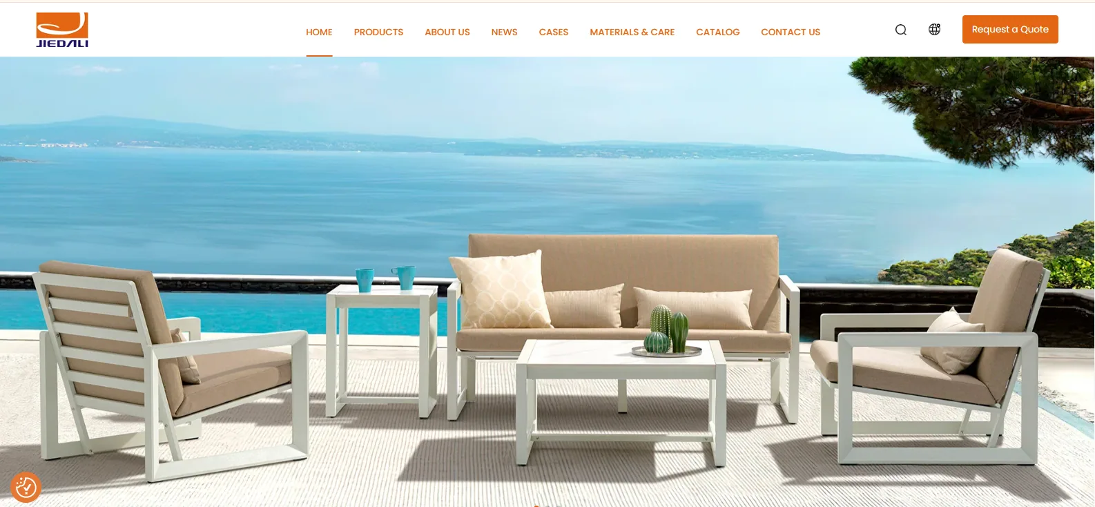 JC Outdoor homepage showing a white aluminum sofa and armchair set with outdoor cushions on a seaside terrace