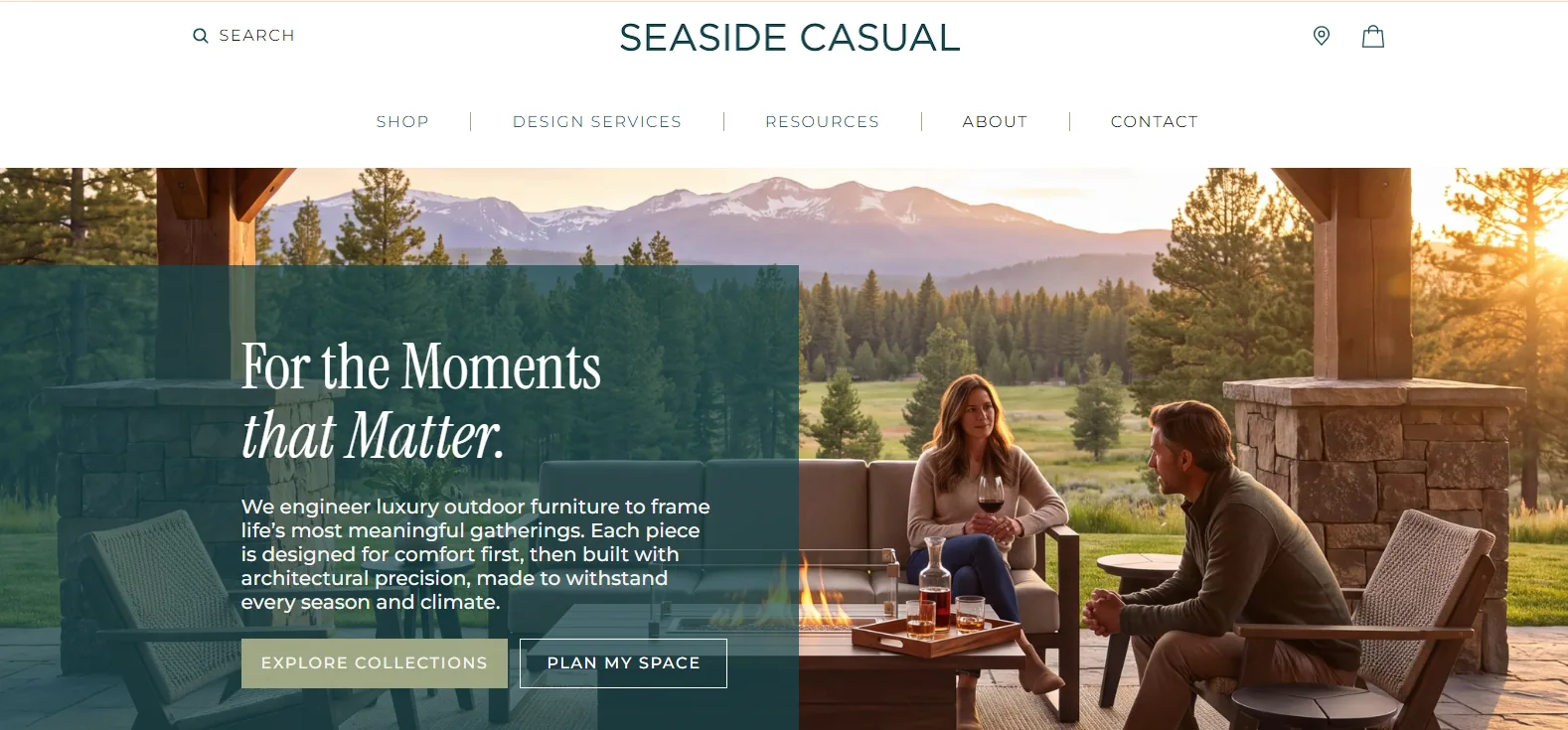 Seaside Casual homepage hero with a couple seated on dark resin lounge chairs around a fire table on a mountain-view terrace at sunset
