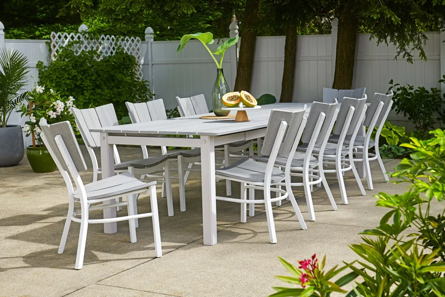 Colourful HDPE poly lumber Adirondack chairs around a white poly table on a lawn